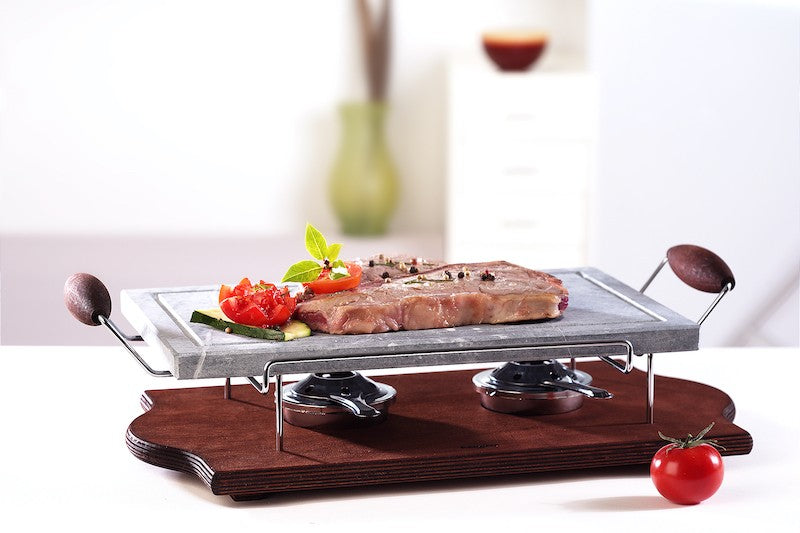 Grande pierre ollaire rectangulaire avec cadre chromé et poêle sur socle en bois wengé